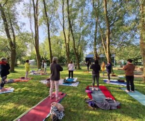 Een rustgevende yoga les in de natuur, buiten tussen de bomen.