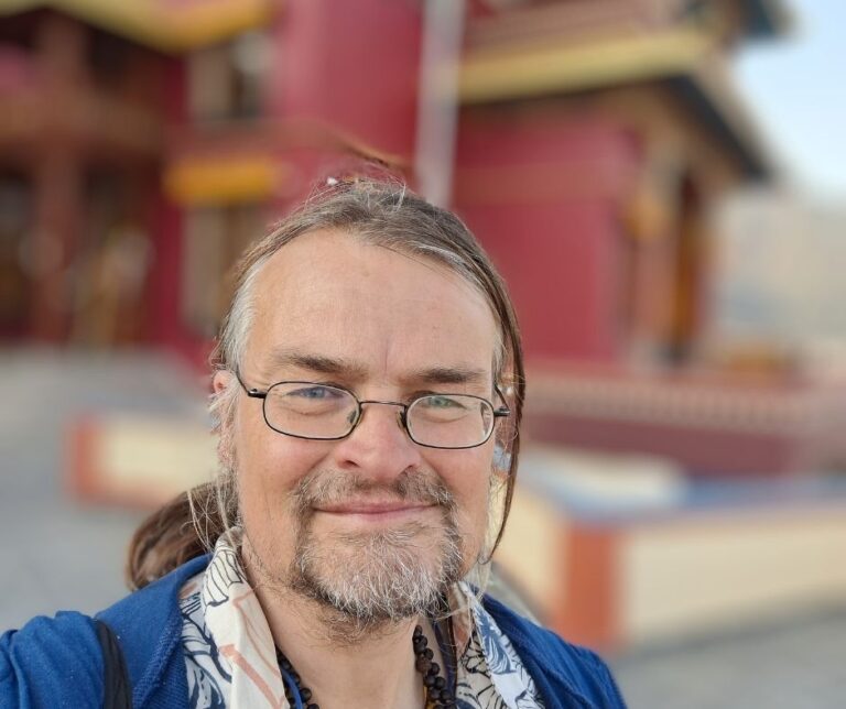 Dhyan Meinoud met de op de achtergrond het klooster van Triten Norbutse in Kathmandu
