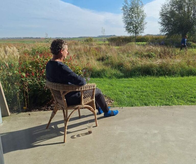 Mannelijke deelnemers aan de stilte retraite zittend in de natuur in de zon in stilte.